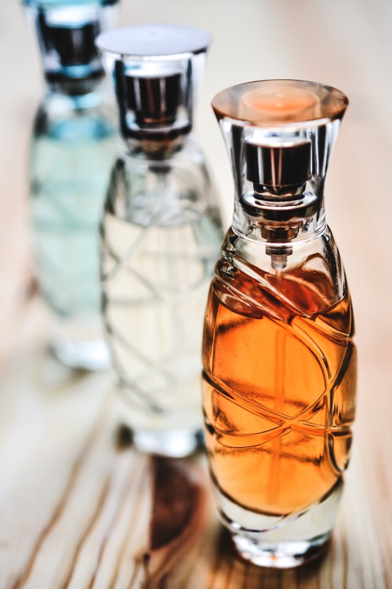 Beautiful collection of glass perfume bottles showcasing different fragrances on a wooden surface.